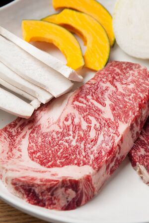 raw sirloin, onions, sweet pumpkins, mushrooms on plateの写真素材