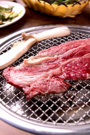 raw sirloin and mushrooms on grillの写真素材
