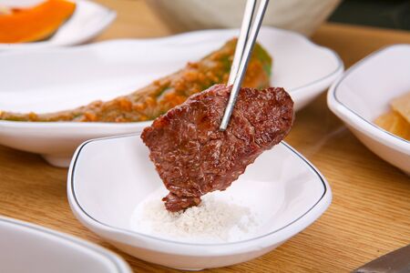 cooked meat dipped into saltの写真素材