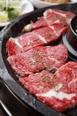 raw sirloin with sprinkled herbs on grillの写真素材