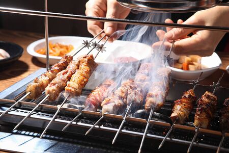 hand grabbing grilled lamb skewersの写真素材