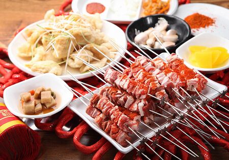 raw lamb skewers with sprinkled red sauce, with side dishesの写真素材