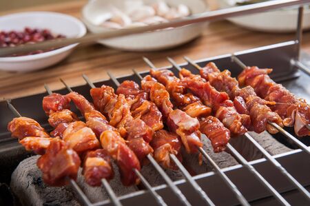 marinated raw lamb skewers being grilled on charcoalの写真素材