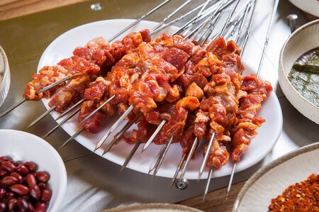 marinated raw lamb skewers on plateの写真素材