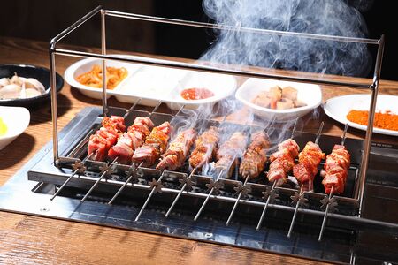 lamb skewers being grilled on grillの写真素材