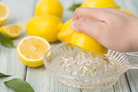 Squeezing lemon with squeezerの写真素材