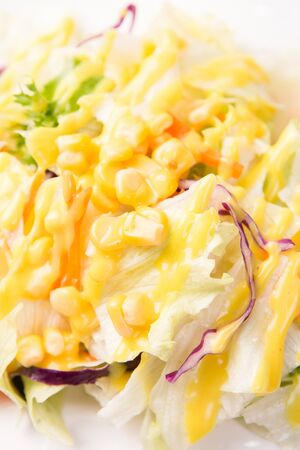 Salad with yellow sauce and cornの写真素材