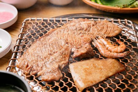 seasoned pork spareribs Galbi, shrimp and pig skin being grilled on panの写真素材