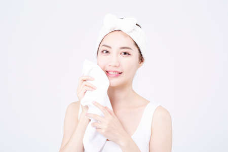 beatiful Asian woman with white sleeveless, white background shot with beauty cosmetics conceptの写真素材