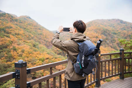 Asian handsome man trekking, climbing autumn mountain