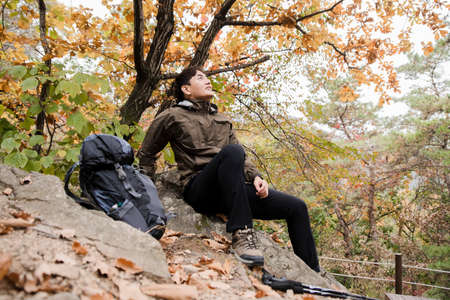Asian handsome man trekking, climbing autumn mountain