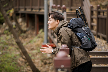 Asian handsome man trekking, climbing autumn mountainの写真素材