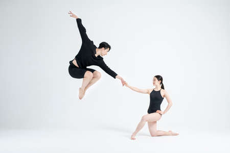 male and female couple modern contemporary dancers making moves in white background settingの写真素材