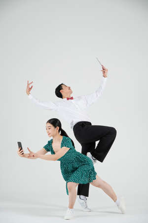 Asian couple contemporary dancers holding tablet and smartphoneの写真素材
