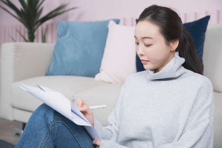 beautiful Asian single solo woman living alone concept writing on papers