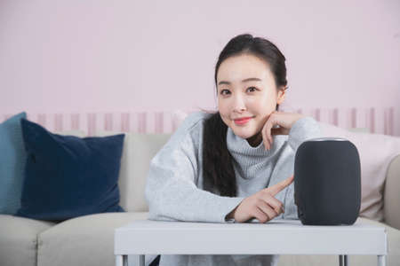 Asian single solo woman living alone concept using artificial intelligence speakerの写真素材