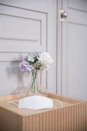 mask on table with flowersの写真素材