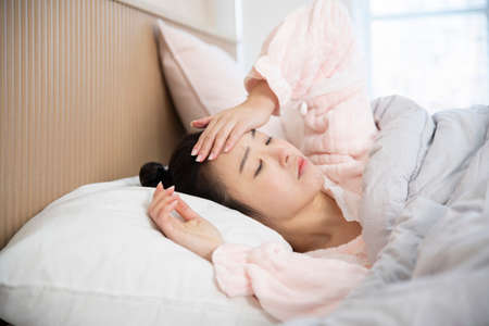 sick Asian woman in bedの写真素材