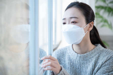 depressed Asian woman wearing mask
