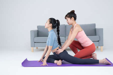 two fit Asian young women home training concept wearing sports top and leggings
