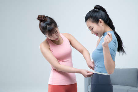 two fit Asian young women home training concept wearing sports top and leggingsの写真素材