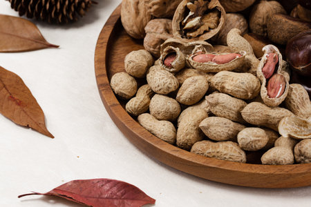chestnuts, peanuts and walnuts with autumn leavesの写真素材
