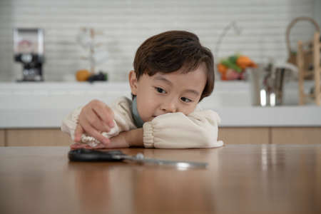 child abuse concept, Asian child with no food at home searching for food or trying to cookの写真素材