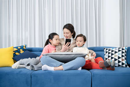 Asian mom and children, sister and brother family concept spending time at homeの写真素材