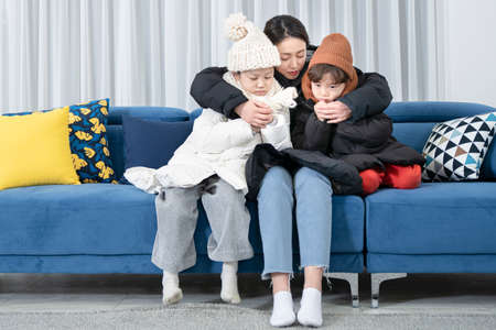 Asian mom and children, sister and brother family concept wearing winter clothesの写真素材