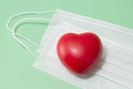heart object on face mask, light green backgroundの写真素材