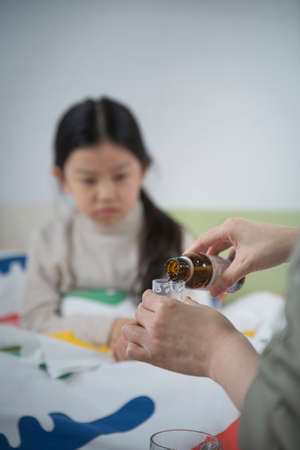 pouring syrup medicine for childrenの写真素材