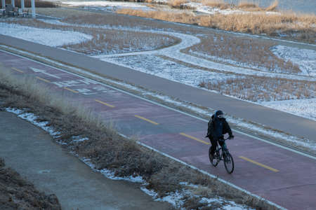 person riding bicycle in cold weatherの写真素材