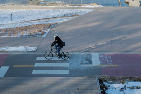 person riding bicycle in cold weatherの写真素材