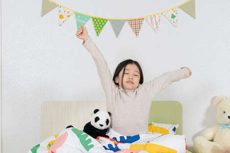 Asian girl awake in bedの写真素材