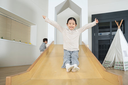 Asian little girl on slideの写真素材