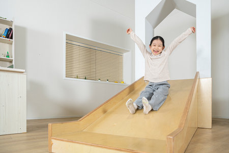 Asian little girl on slideの写真素材