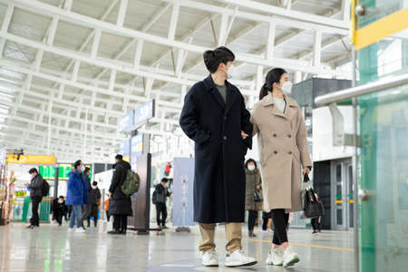 Asian couple with face masks in train stationの写真素材