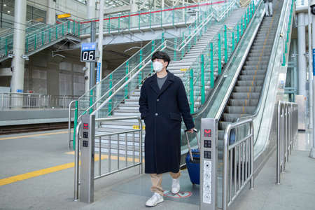 Asian man and woman with masks in escalator