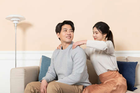 Asian husband massaging shoulders of wife