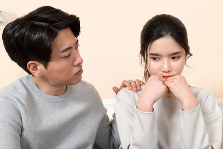 Asian husband comforting, calming down Asian wifeの写真素材