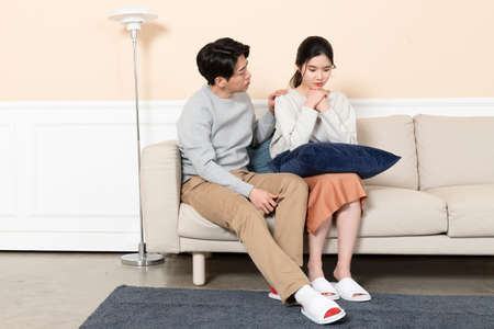 Asian husband comforting, calming down Asian wifeの写真素材