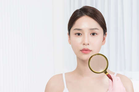 beautiful Asian Korean model holding magnifying glass, beauty conceptの写真素材