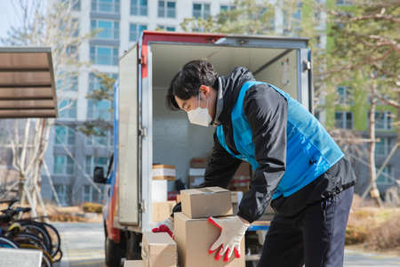 Asian delivery man, delivering boxes, goods to customers