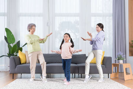 three generations of women, Asian grandmother, mother and grand daughter dancing