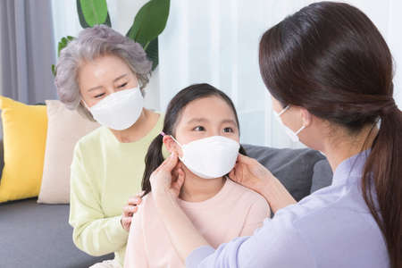 three generations of women, Asian grandmother, mother and grand daughter wearing mask