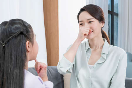 Asian mother and young daughter communicating in sign languageの写真素材