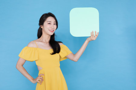 beautiful Korean Asian model with blank signboard, with empty copy space place for some text, advertising or sloganの写真素材