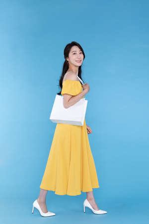 shopping event concept, beautiful Korean Asian woman with shopping bag in shoulderの写真素材
