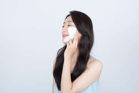summer skin care, beautiful Asian woman with facial pack on cheekの写真素材