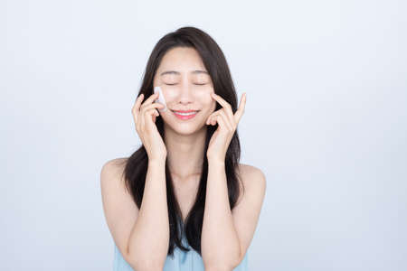 summer skin care, beautiful Asian woman with toner pads on faceの写真素材